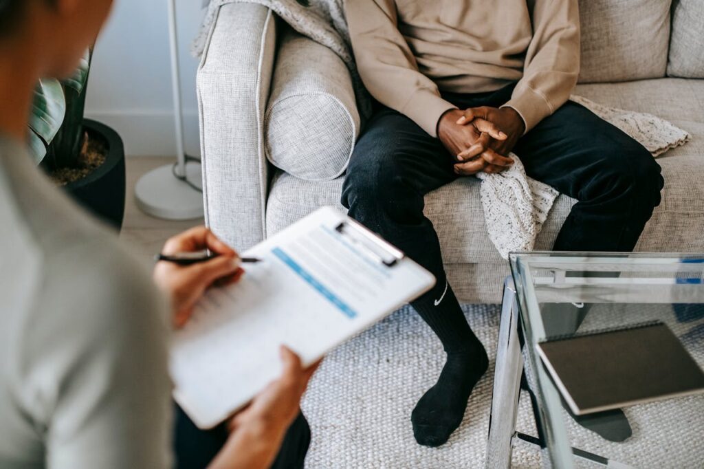 Clinician taking notes while talking with patient