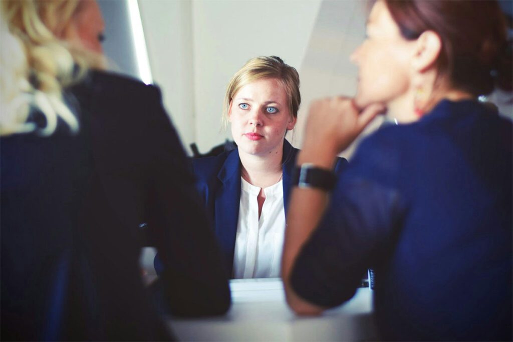 Woman sitting across from colleagues at work