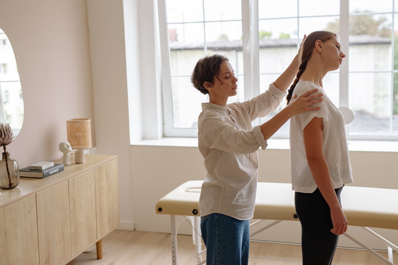 Physical therapist working with a patient’s neck while standing