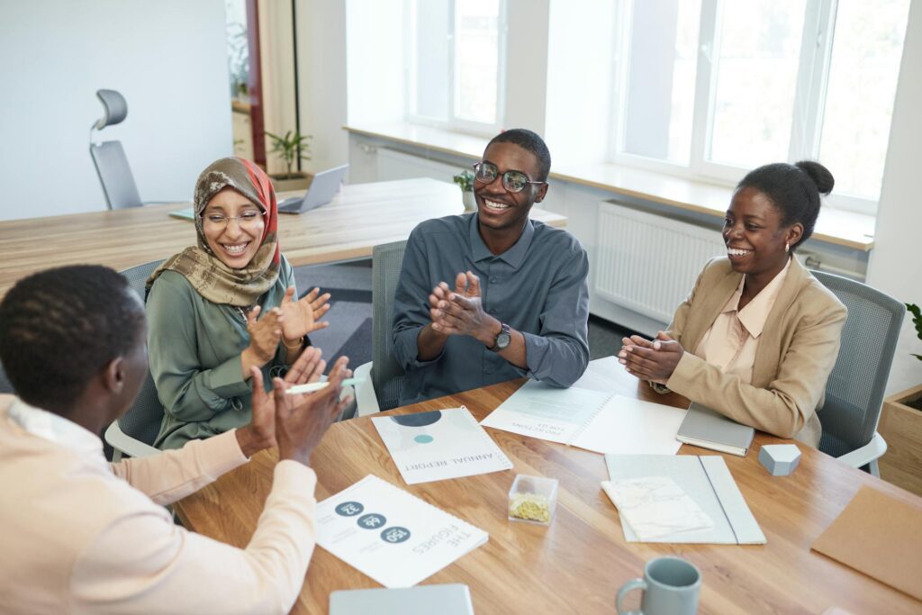 Group of employees around table clapping