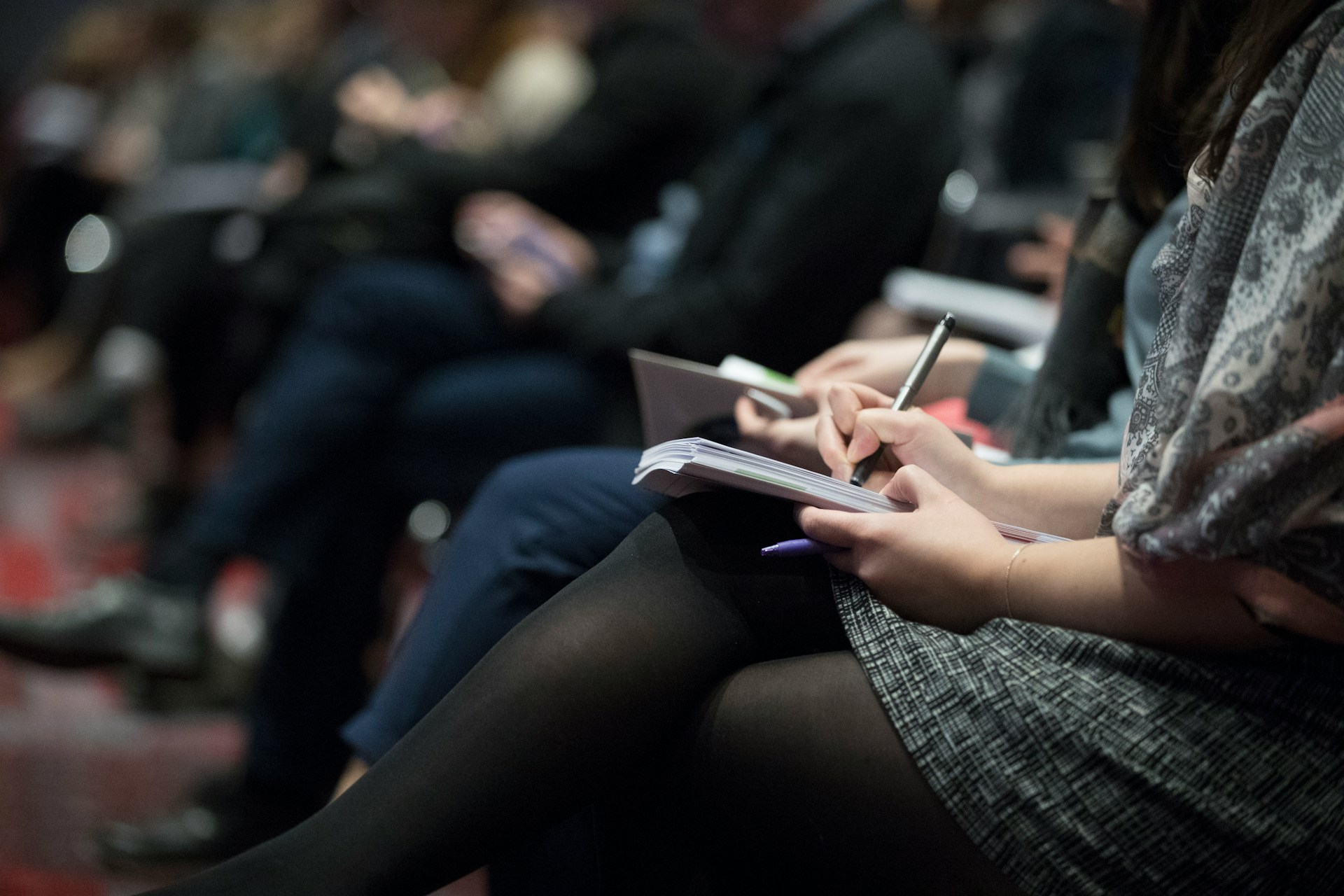 Side view of woman taking notes at a conference