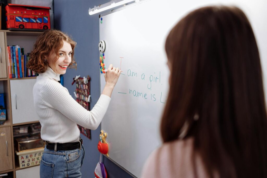 A clinician stands by a whiteboard with a student.