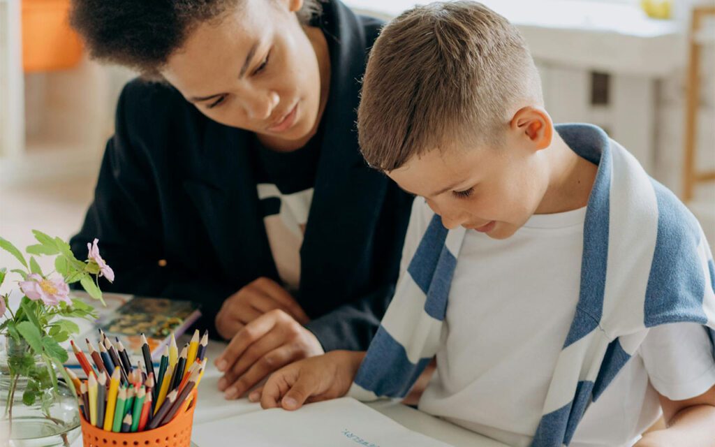 An SLP employee works with a child in a school’s classroom