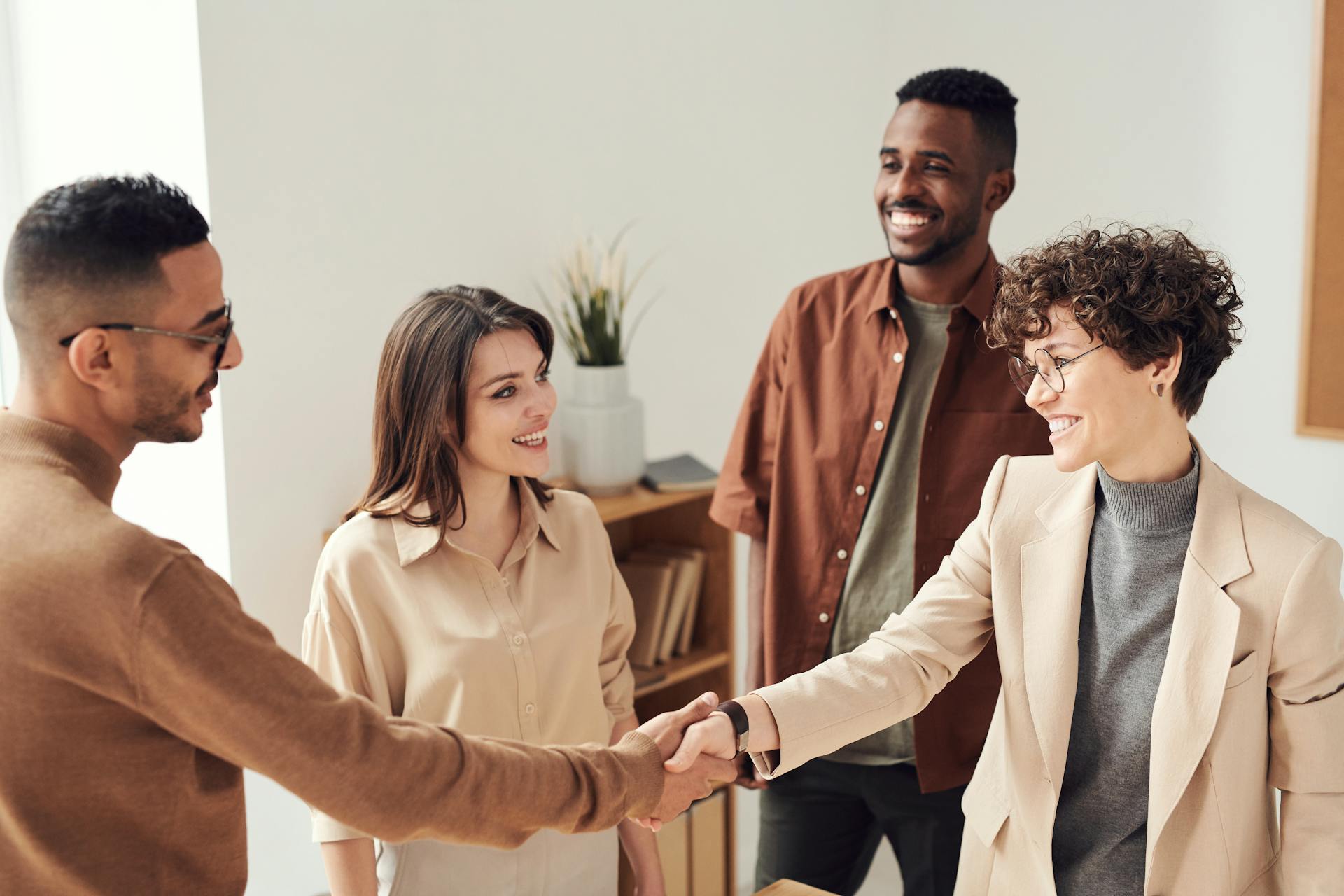 A team of SLPs shakes hands with a new job hire.