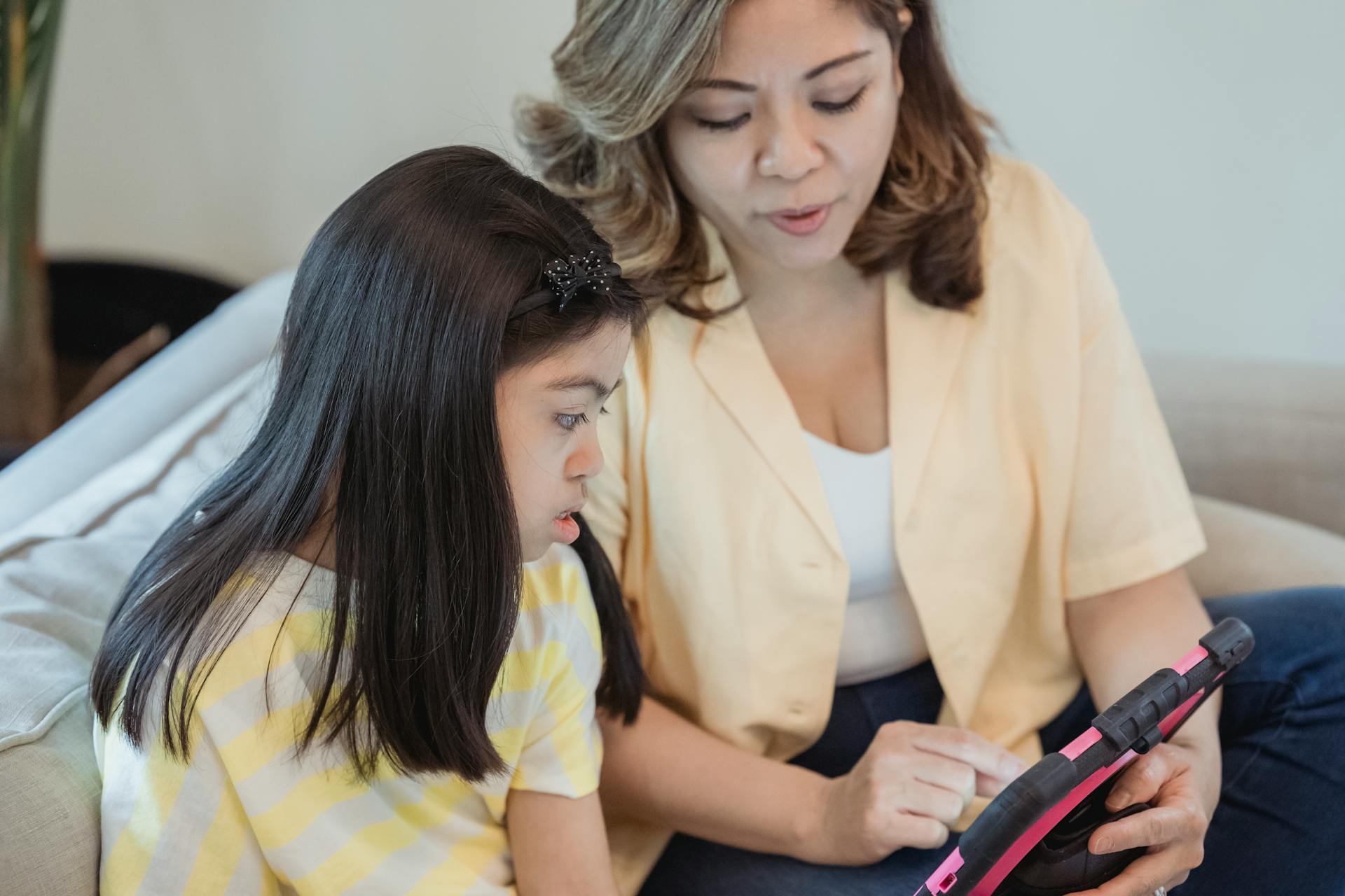 A speech pathology clinician uses tablet technology with a young child.