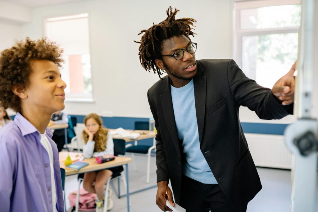 A speech-language pathologist works with a student in a classroom.