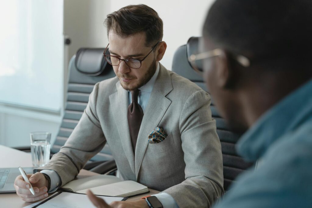 An employment officer takes notes while speaking with an SLP job candidate.